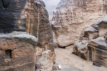 Stone houses or Tombs in curved rocks at heavy rain in Little Petra - ancient Nabatean city. Jordan