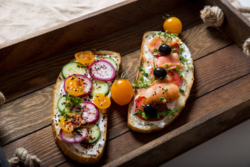 Healthy and tasty toast bread with tomato, radish, salmon fish and cheese on it.