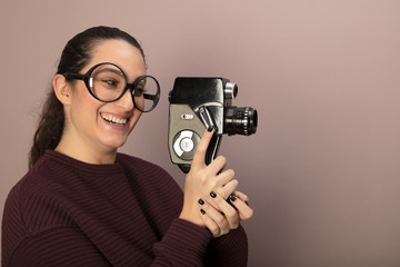 Nerdy young woman holding a vintage film camera