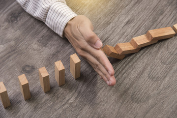 hand stopping wooden block domino. concept prevent and solution. - obrazy, fototapety, plakaty