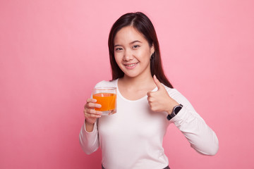 Young Asian woman thumbs up drink orange juice.