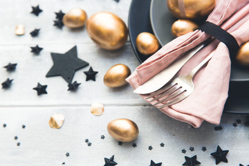 Glamour easter table setting with gold eggs.