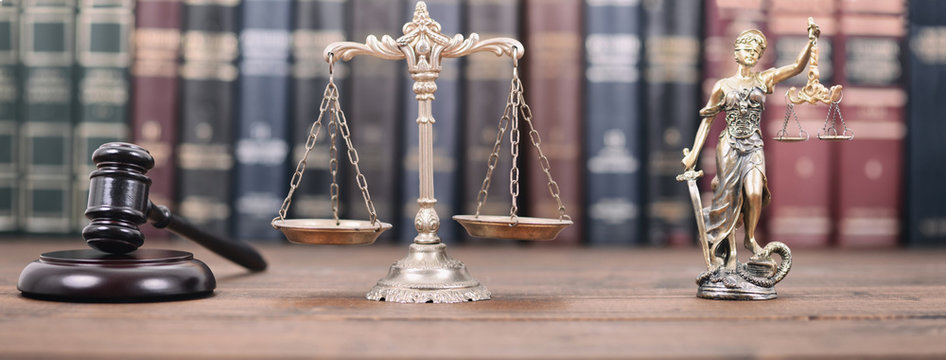 Lady Justice, Scales of Justice and Judge Gavel on a  wooden background.