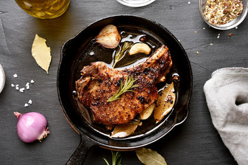 Pork steak in frying pan, top view