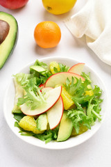 Salad with red apples, avocado, orange slices