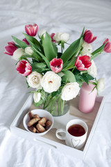 Romantic breakfast in bed. Bouquet of flowers. Roses and tulips. Spring. Valentine's Day. International Women's Day. Cozy.