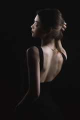  slim slim girl in dress with neckline in glamorous light from back