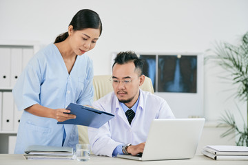 Nurse giving document to doctor