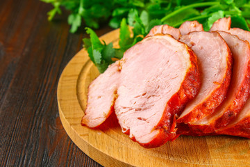 Sliced Roast Pork Loin on a brown wooden table with cilantro.
