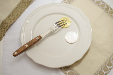golden and silver bitcoin on plate with fork