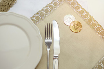golden and silver bitcoin on plate with fork