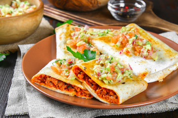 Traditional Mexican dish - chimichanga. Corn cake with minced meat, pepper, onion, garlic, oregano, zira and guacomole sauce from avocado.