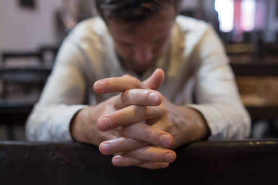 caucasian man praying in church. He has problems and ask God for help