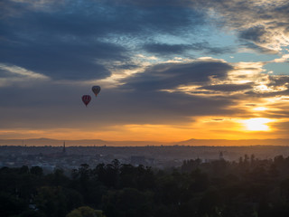 Hot air balloons fly over the Melbourne sunrise.