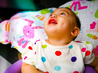 Candid portrait of a cute and expressive Asian baby girl. Lifestyle and childhood concept.