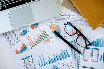 Office desk table with computer, analysis chart, calculator and pen. Vintage tone Retro filter effect,soft focus,low light.(selective focus)