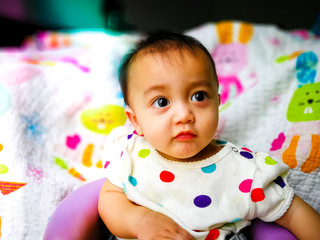 Candid portrait of a cute and expressive Asian baby girl. Lifestyle and childhood concept.
