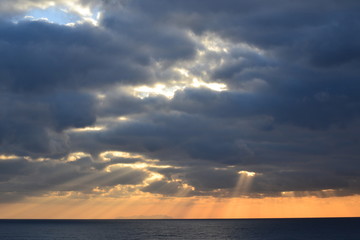 sonnenuntergang über dem Meer, Sonnenstrahlen zwischen den Wolken