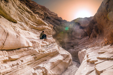 beau jeune homme contemplant le coucher de soleil dans un canyon
