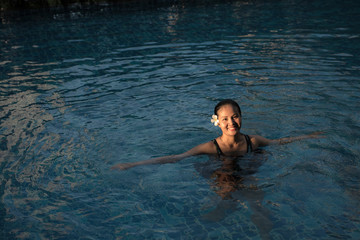 Smiling portrait of beautiful woman in swimming pool,Beautiful young woman relaxing in spa swimming pool.