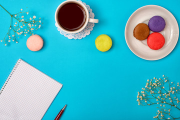 Colorful sweet macaroons and a cup of tea. Delicious breakfast. Romantic mood.Plans for the day.