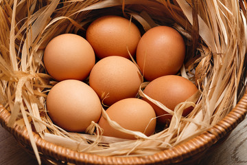 Chicken eggs on a straw in a basket