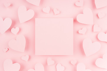 Fototapeta na wymiar Blank pink square page with paper hearts on light background. Advertesign concept for Valentine day.