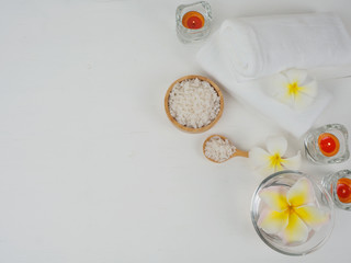 spa wellness set.beauty and fashion set on the white table.spa towel with candle and plumeria, tree on the white table.
