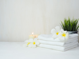 spa wellness set.beauty and fashion set on the white table.spa towel with candle and plumeria, tree...