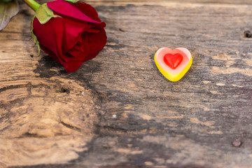 Tasty Jelly candies shaped heart with red rose nearby