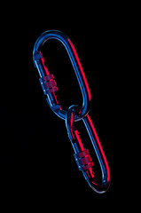 Chains of metal carabiners over black background