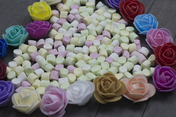 sweet marshmallows in heart shape decorated with flowers on wood background. valentine day concept.