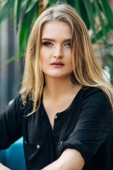 Portrait of gorgeous young blonde woman in a black dress