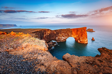 Amazing black arch of lava standing in the sea. Location cape Dyrholaey, Iceland, Europe.