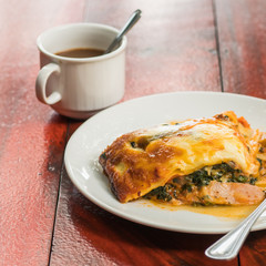 Portion of tasty lasagna with a cup of coffee
