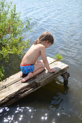 child on the bridge near the water