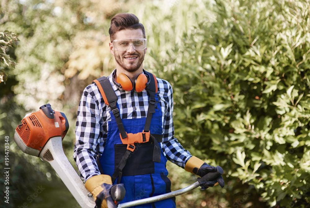 Wall mural portrait of man working with weedwacker