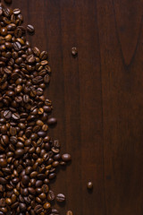 Spilt coffee beans on wood surface table.
