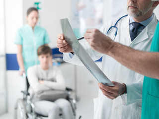 Professional doctors examining patient's x-ray