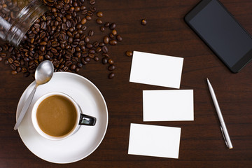 Cup of coffee from above, lay flat image, with coffee beans on wood table.