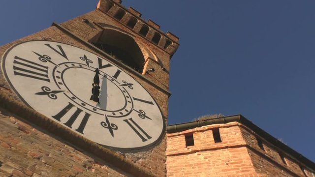 Medieval tower in a castle with a nice white clock, filmed from left to right.