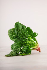 freshly harvested spinach on white wooden kitchen  plate can be used as background