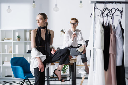 stylish young fashion designers sitting on work desk at office