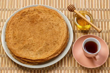 breakfast tea with pancakes and honey on wooden background