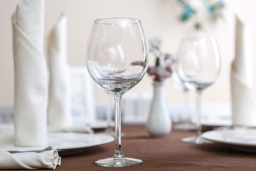 Empty glasses are installed in the restaurant on the table. Part of the interior