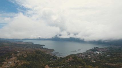 Fototapeta na wymiar Lake Batur in the crater of a volcano. Aerial view of volcano mount and lake Batur located in Kintamani area in Bali, Indonesia. Landscape, lake, mountains, clouds. Travel concept.