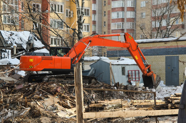excavator dismantles dilapidated housing