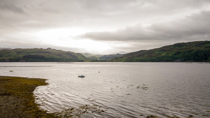 Loch Carron, Highlands, Scotland. An overcast sky over the calm waters of Loch Carron with the hills of the Scottish Highlands on the distant shore.