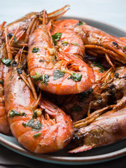 Grilled shrimps with parsley on pastel turqouise background. Shellfish dish