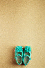 Turquoise shoes for baby girl over beige background